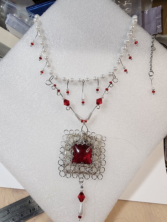 Necklace with red gemstones and faux pearls.